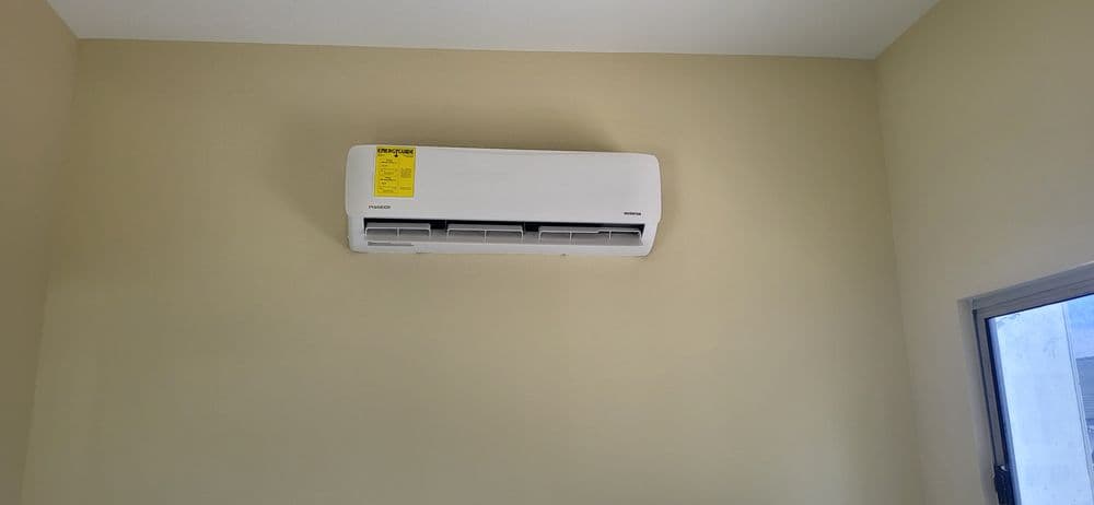 Modern wall-mounted air conditioning unit in a light-colored room.
